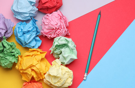 Colored balls of crumpled paper and paper sheet with pencil. Lack of ideas, stress, depression, business conceptの写真素材