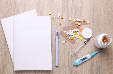 Blank medical journal or notebook with white cover and medicines on table. Mockup for designの写真素材