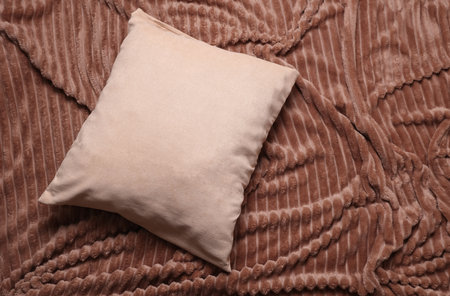 Brown Pillow on a bed blanketの写真素材