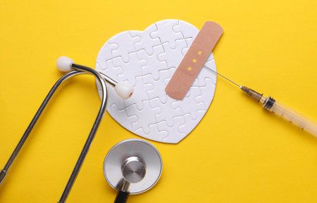 Stethoscope, medicines and white puzzle in the shape of heart. Diagnosis and treatment of heart diseases. Mockup for designの写真素材