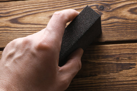Man's hand sanding wooden boards with a sanding blockの写真素材