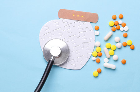 Stethoscope, medicines and white puzzle in the shape of heart. Diagnosis and treatment of heart diseases. Mockup for designの写真素材