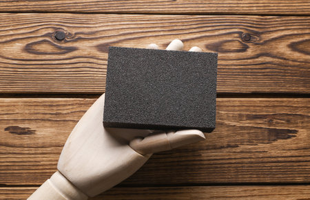 Hand holding sanding block on wooden boardsの写真素材