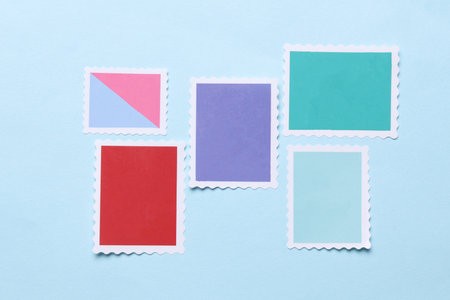 Blank Postal paper adhesive stamps on blue background. Marks for letterの写真素材