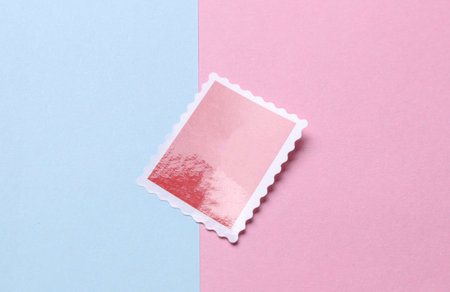 Blank Postal paper adhesive stamp on  pink blue backgroundの写真素材