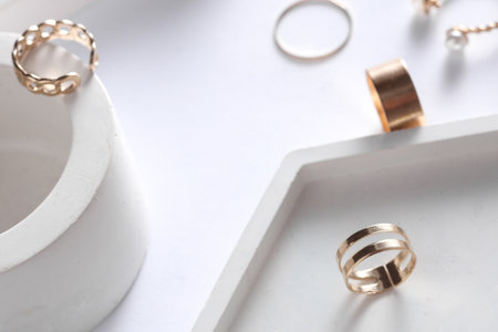 Gold rings of different shapes with plaster tray on white background. Podium showcase for product presentation. Women's jewelry store concept. Creative layoutの写真素材