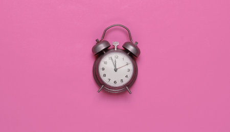 Retro alarm clock on pink background. Top viewの写真素材