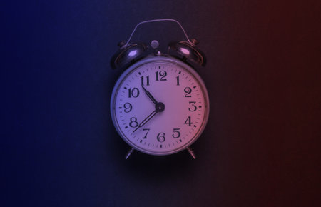 Retro alarm clock in neon light. Top view