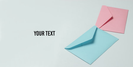Two envelopes of pink and blue pastel colors on white background. Mockup for valentines day, wedding or birthday. Copy spaceの写真素材