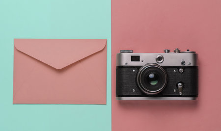 Envelope, retro camera on pink blue pastel background. Top view. Travel conceptの写真素材