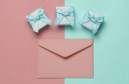 Envelope, boxes of gifts on pink blue pastel background. Christmas, Valentine's day, wedding or...