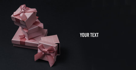 Stack of Gift boxes with bows on black studio background. Composition for christmas, birthday or...