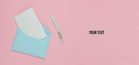 Envelope with a letter and pen on pink pastel background. Valentine's day, wedding or birthday. Top...