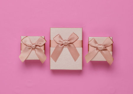 Gift boxes with bow on pink background. Composition for christmas, birthday or wedding.の写真素材