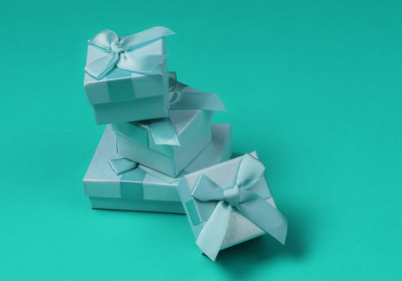 Stack of gift boxes with bows on blue studio background. Composition for christmas, birthday or...