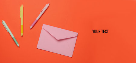 Envelope and colored pens on orange background. Top view. Copy space
