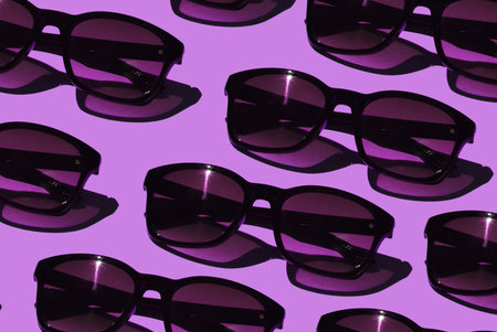 Pop art background. Stylish sunglasses on pink background. Fashion shot with shadows.の写真素材
