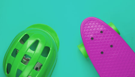 Cruiser board and safety helmet on a blue background. Protective equipment for sports. Childhood. Top viewの写真素材