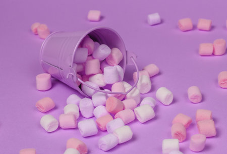 Mini bucket with a lot of marshmallows on a pink pastel background. Minimalism. Sweets