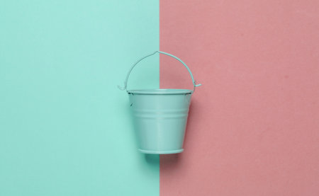 Blue empty mini bucket on pink blue pastel background. Minimalism. Trend color concept. Top viewの写真素材