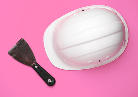 Trowel and construction helmet on pink background. Builder equipment. Top viewの写真素材