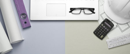 Creative layout of architects with roll drawings, architectural project plan, engineering tools and stationery, laptop on pastel background, workspace. Top view. Flat lay. Copy spaceの写真素材