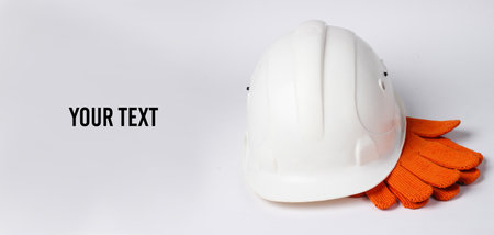 Safety equipment on a white background. Construction helmet, gloves on a white background. Copy spaceの写真素材
