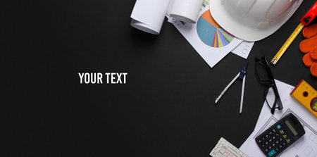 Creative layout of architects with roll drawings, architectural project plan, engineering tools and stationery on black background, workspace. Top view. Flat lay. Copy spaceの写真素材