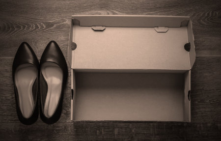 New leather heeled shoes with a cardboard box on the floor. Top view