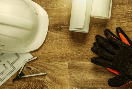 Creative layout of architects with roll drawings, architectural project plan, construction helmet and tools on floor, workspace. Top view. Flat layの写真素材