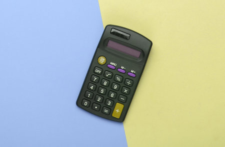 Black calculator on yellow blue background. Top viewの写真素材