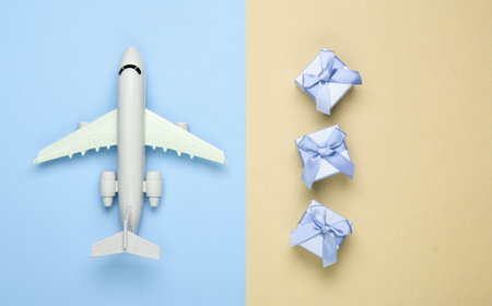 Air delivery. Plane figurine and gift boxes on yellow blue pastel background. Flat lay. Top view