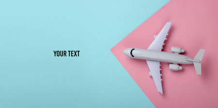 Toy model of plane on a blue-pink pastel background. The concept of tourism, air travel, minimalism. Top view. Copy spaceの写真素材