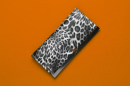 Stylish wallet on orange background. Fashion minimalism. Top view