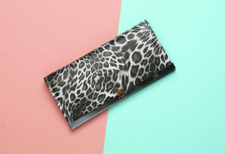 Stylish wallet on pink blue pastel background. Fashion minimalism. Top view