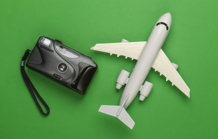 Flat lay design of travel concept with plane, camera. Green background. Minimalism. Top viewの写真素材