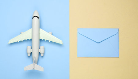 Air mail, air delivery. Flat lay composition with airplane figure and envelopes of letters on yellow blue pastel background. Top viewの写真素材