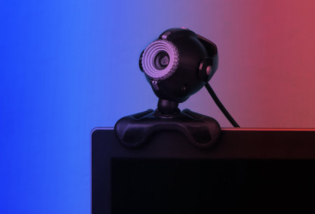 Fragment of a monitor with a web camera in neon light.