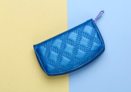 Blue wallet on blue yellow background. Top view. Fashion minimalism