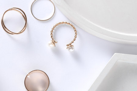 Gold rings of different shapes with plaster tray on white background. Podium showcase for product...