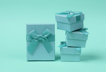 Stack of Gift boxes with bows on blue pastel background. Composition for christmas, birthday or wedding.の写真素材