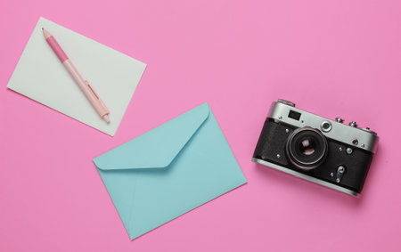 Envelope, retro camera on pink pastel background. Top view. Travel conceptの写真素材