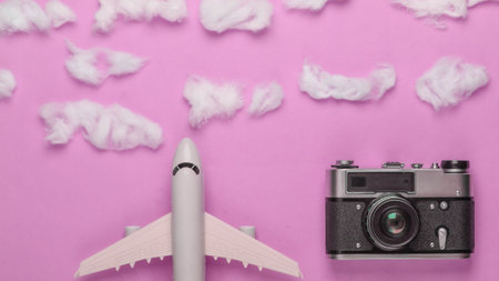 Flat lay design of travel concept with plane, clouds and camera. Minimalism. Top viewの写真素材