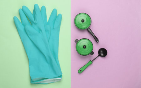Flat lay composition of cleaning gloves, toy kitchen tools and utensils on pastel background. Top viewの写真素材