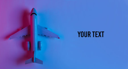 Airplane figurine with neon blue-pink light. Top view. Copy space