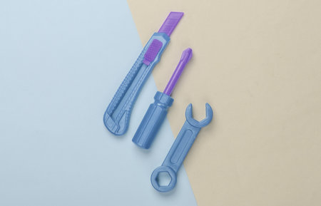 Children's toy tool. Wrench, screwdriver on colored pastel background. Top view