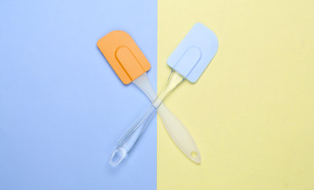 Two kitchen spatula on yellow blue pastel background. Minimalism. Top viewの写真素材