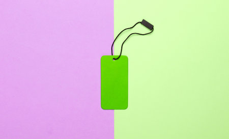 Green tag on pink green pastel background. Top view. Discount. Minimalismの写真素材