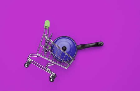 Miniature shopping trolley with pan on pink background. Top viewの写真素材