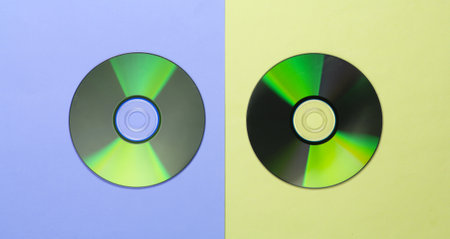 Flat lay composition of cd disc on a yellow blue background. Top view